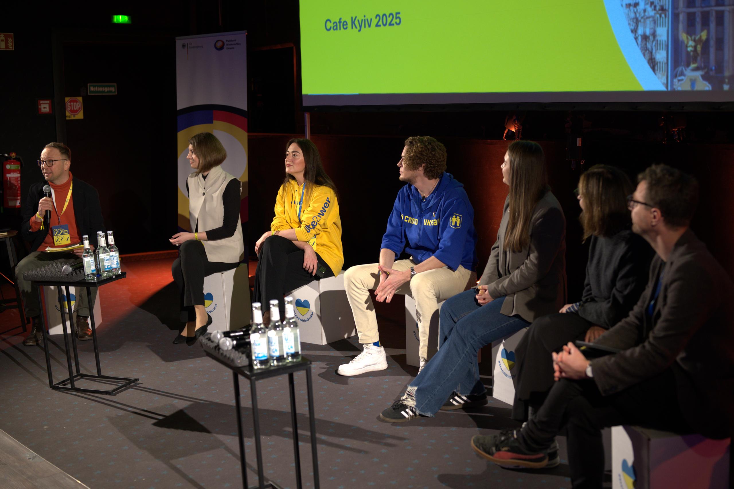 Andriy Garbuza (Sekretariat der Plattform Wiederaufbau Ukraine), Lily Nabochenko (Mykolaiv Water Hub), Nataliia Fiebrig (Ukraine2Power), Alexander Tebbe (Crowd Ukraine), Julia Chenusha (Blau-Gelbes Kreuz), Małgorzata Ławrowska-von Thadden (OBMIN) und Stefan Henkel (Europa-Universität Viadrina) auf dem Panel "Synergien für den Wiederaufbau: Was können Partnerschaften bewirken?“