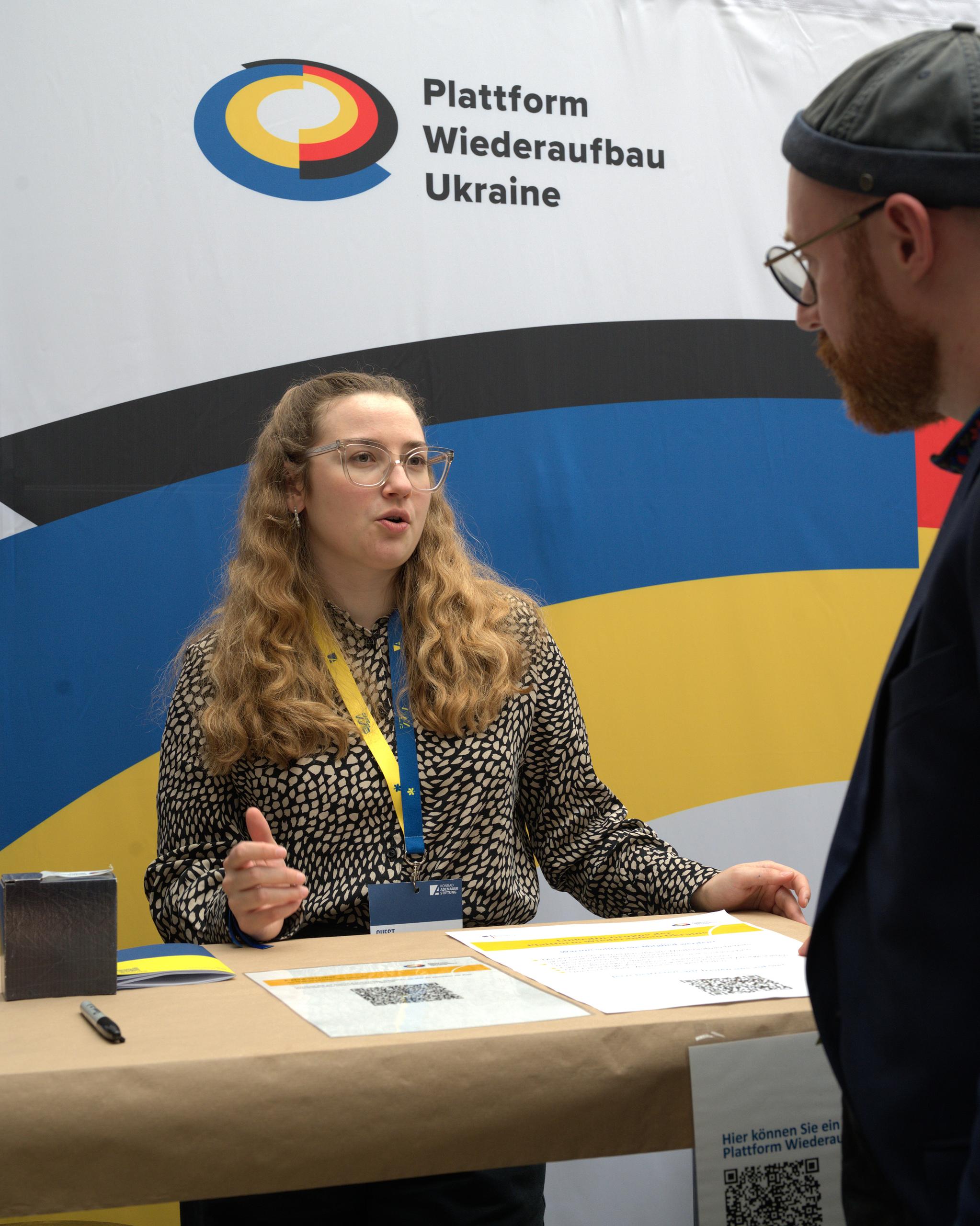 Welche Ziele verfolgt die Plattform Wiederaufbau Ukraine? Der Stand im ersten Obergeschoss des Berliner Colosseum bietet ausreichend Platz für Austausch.