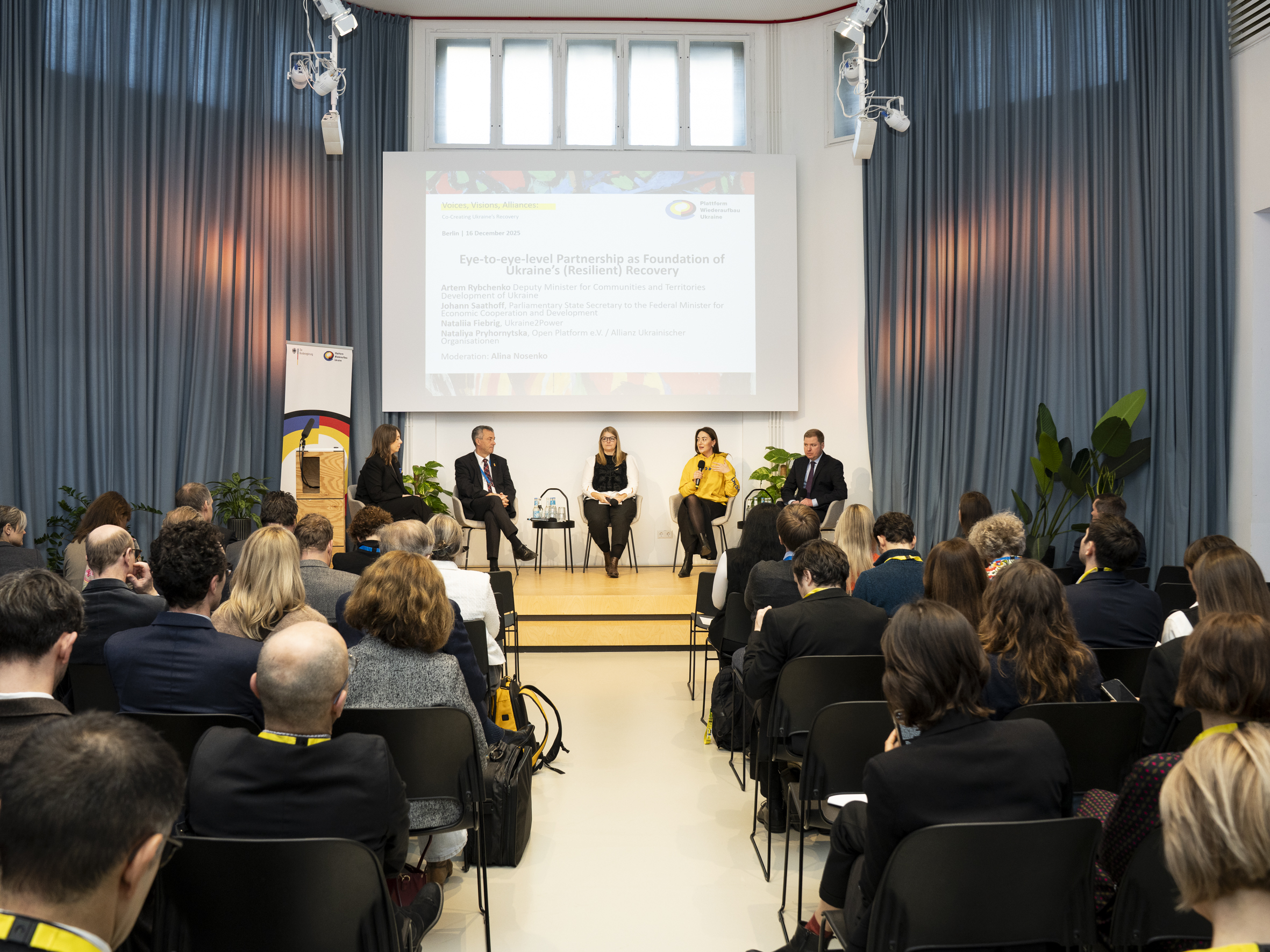 Blick aus dem Publikum auf eine Paneldiskussion mit fünf Leuten