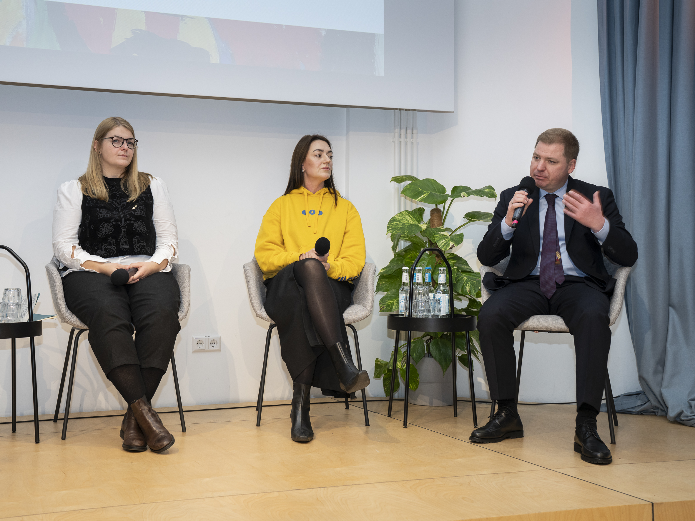 Zwei Frauen und ein Mann auf einer Bühne