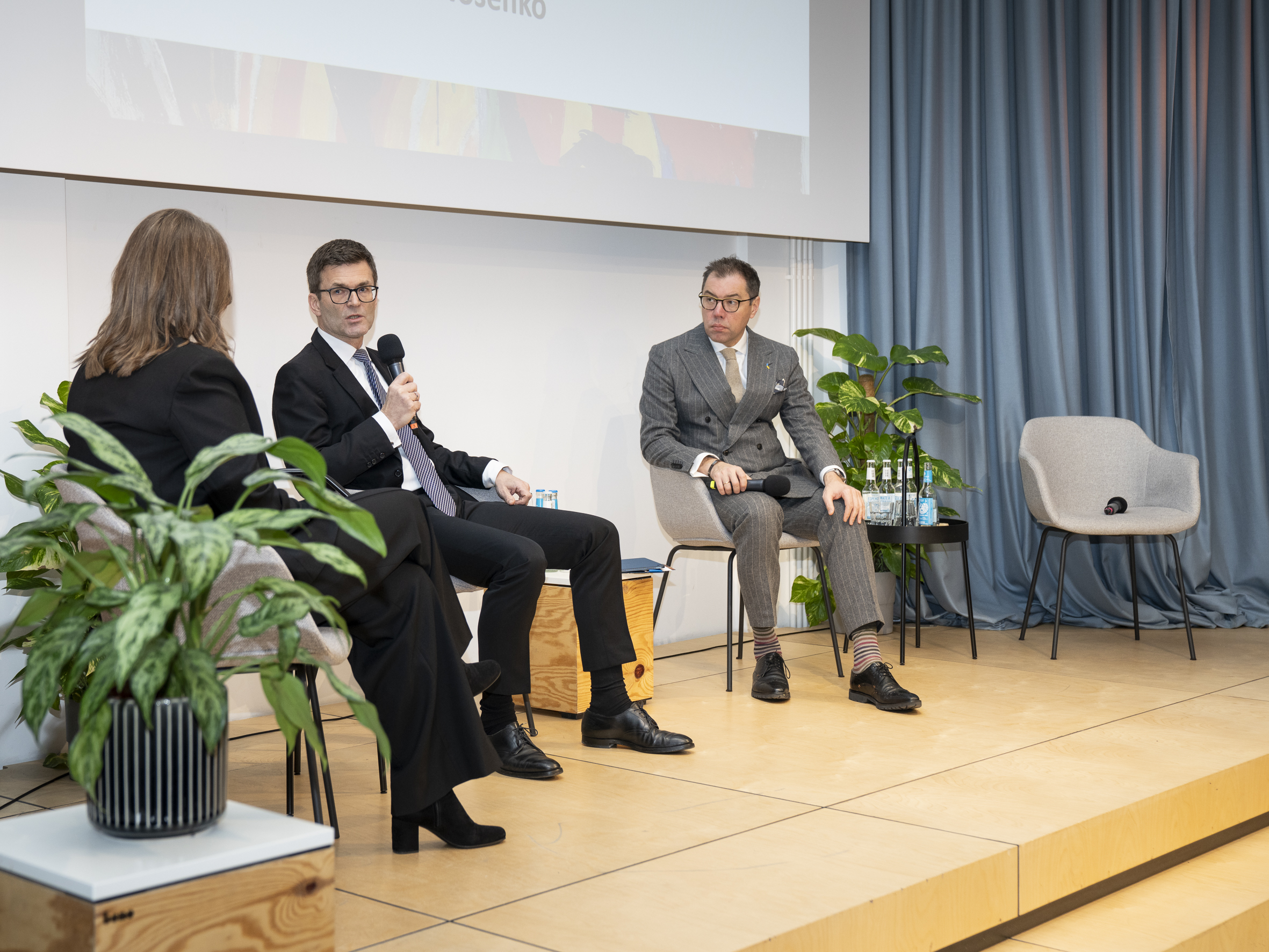 Zwei Männer und eine Frau auf einer Bühne