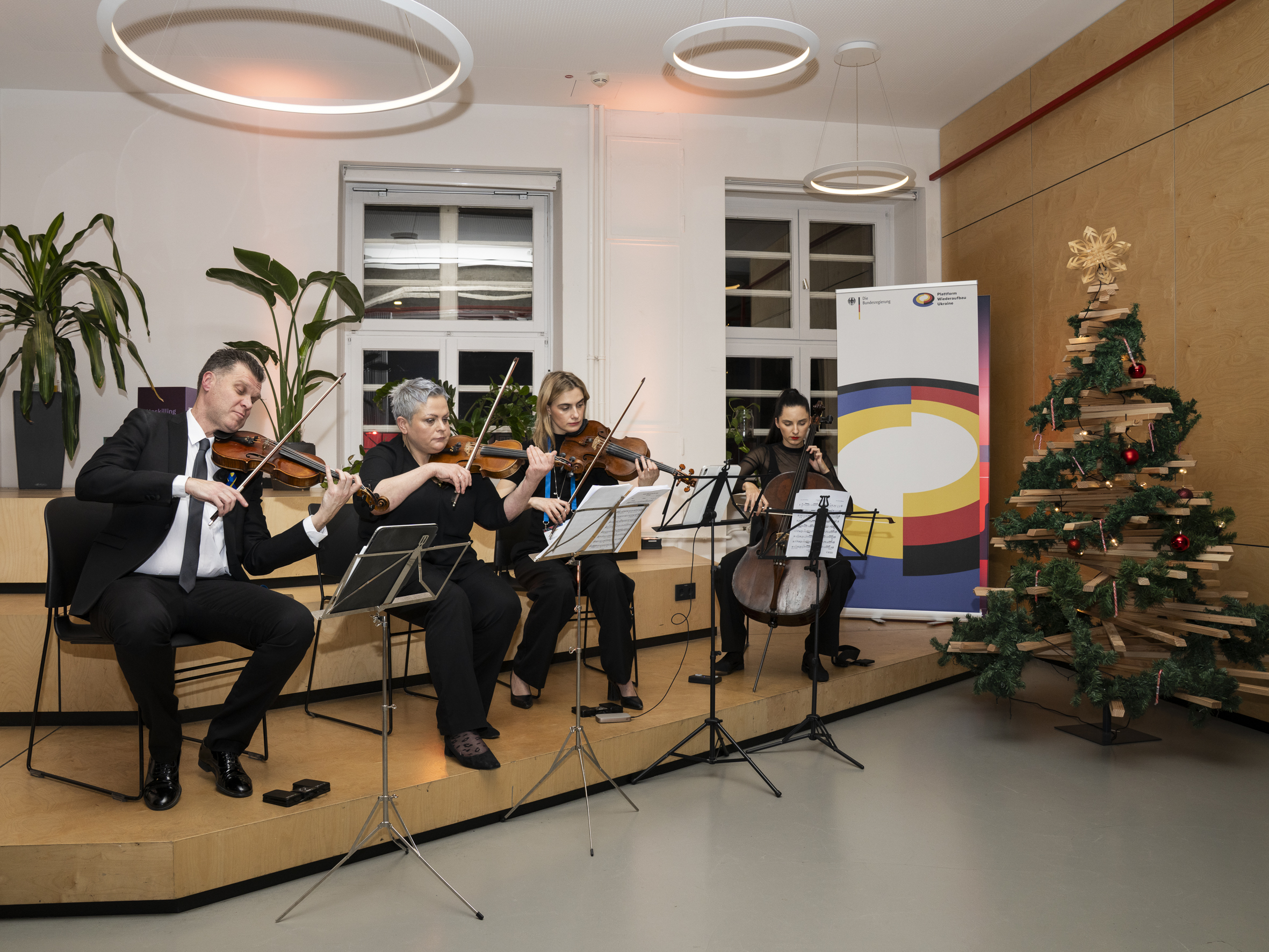 Vier Geigenspieler auf einer Bühne