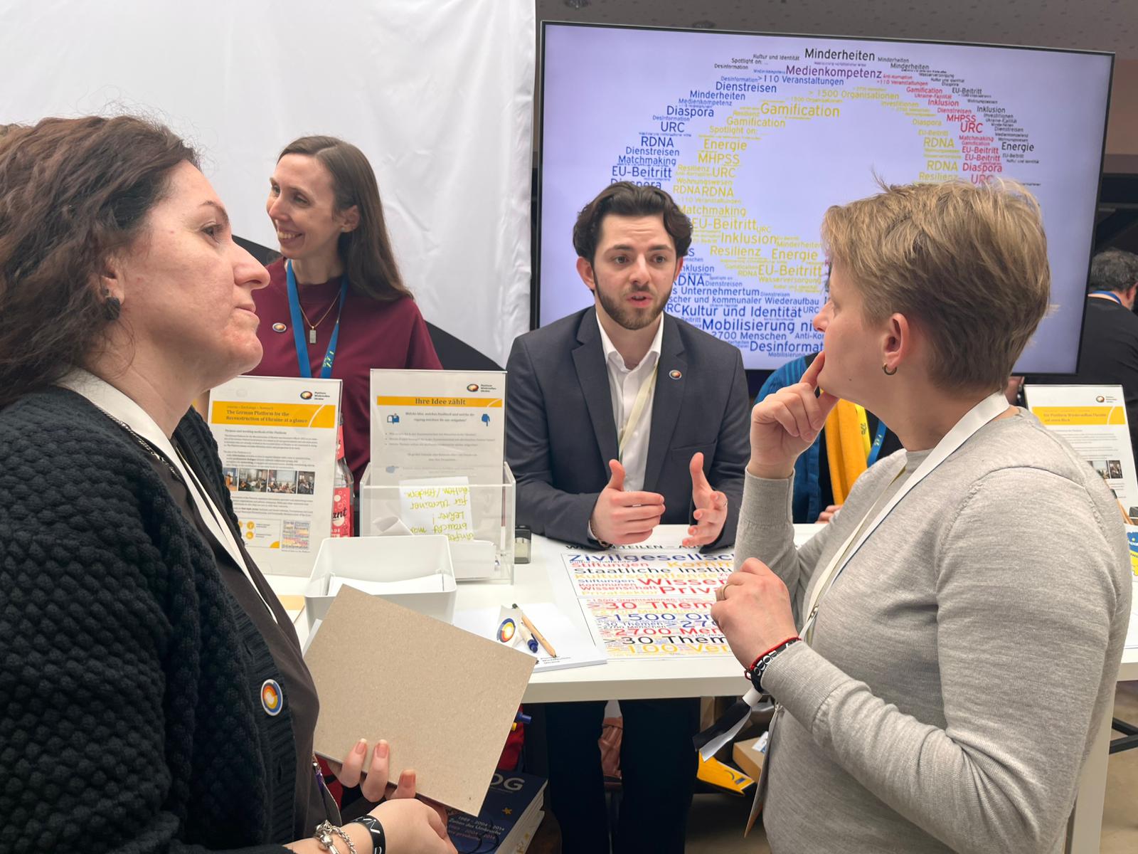 Foto von vier Menschen an einem Messestand.